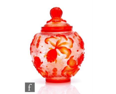 An early 20th Century Peking Glass cameo jar and cover, the footed ovoid jar rising to a domed cover with finial, the body ca