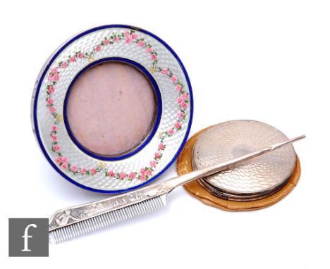 A hallmarked silver circular easel photograph frame with enamelled pink roses to a white guilloche ground within blue borders