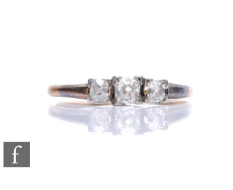 An early 20th Century 18ct diamond three stone ring, old cut stones to a square setting and knife edged shoulders, weight 2.5