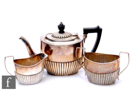 A hallmarked silver three piece boat shaped bachelor's tea set with part fluted decoration, total weight 12.5oz, Chester 1901