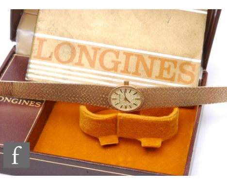 A 9ct hallmarked lady's Longines manual wrist watch, gilt batons to an oval champagne dial and integral 9ct bracelet, total w