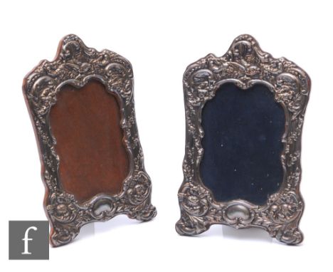 A pair of hallmarked silver shaped rectangular easel photograph frames each with embossed foliate decoration, height 20cm, Bi