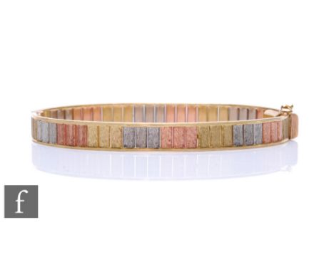 A 9ct hallmarked tri-coloured hinged stiff bangle, weight 14.5g, terminating in tongue and box snap. 