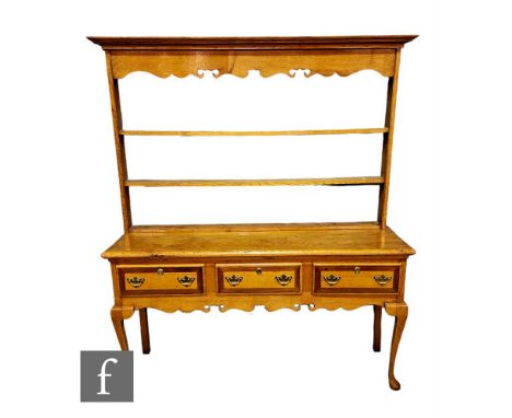 A George III style light oak three drawer dresser, the three tier apron rack over a mahogany crossbanded three drawer base, o
