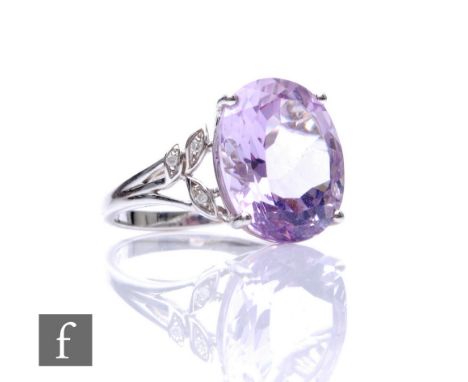 A 9ct white gold amethyst and diamond ring, central oval amethyst with three diamonds to scrolled shoulders, weight 4.8, ring
