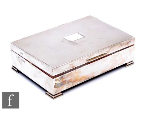 A hallmarked silver rectangular cigarette box with engine turned decoration and raised on four bracket feet, length 17cm, Bir