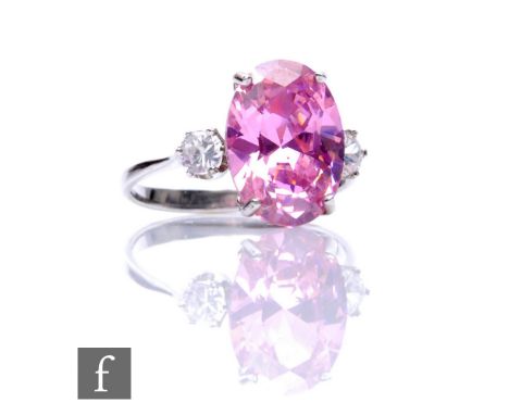 A 9ct hallmarked kunzite and cubic zirconia three stone ring, central oval kunzite flanked by a cubic stone to each side, wei