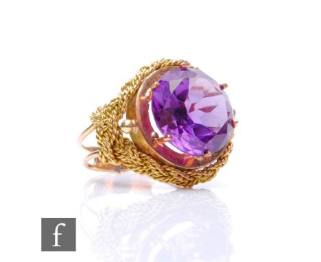 A 14ct single stone amethyst ring, circular claw set stone, diameter 13mm, to a rope twist decorated border and split shoulde