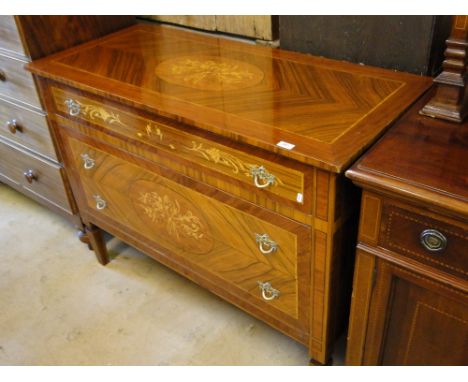 An Empire style crossbanded walnut commode, with 3 long drawers raised on square tapered legs.
