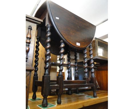 An oak barleytwist gateleg table and a stained wood 3-tier hanging shelf.