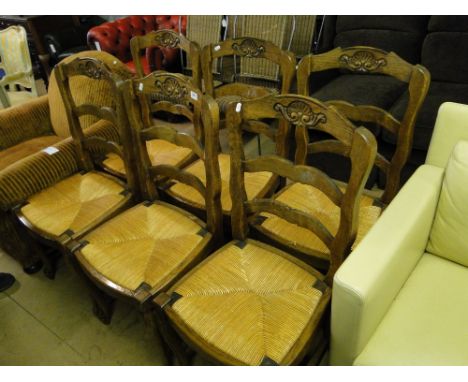 A set of 6 French carved oak ladder back dining chairs.