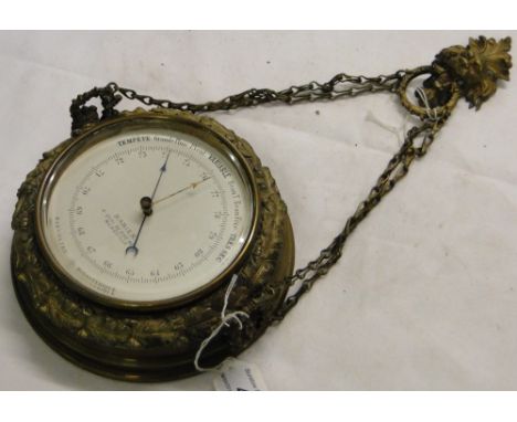 A wall barometer in ornate gilt metal frame, with hanger