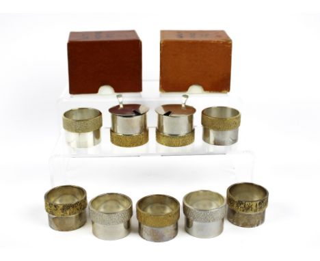 Two silver and silver gilt mustard pots and seven napkin rings, all marked London , mustard pots 1977 and  napkin rings 1976,