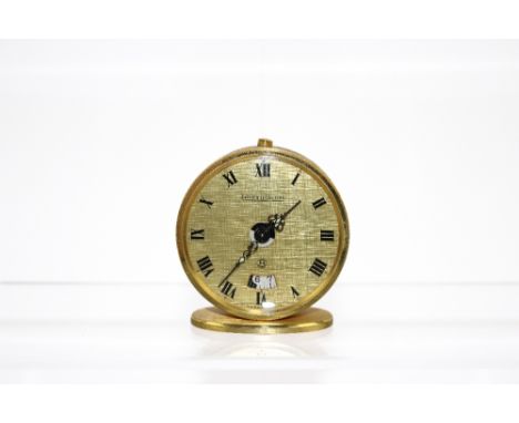 A Jaeger-Le-Coultre miniature eight day travel alarm clock , having a 45mm gilt case and dial with alarm aperture and Roman n