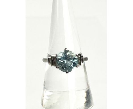 An Aquamarine and Diamond ring , set with a circular aquamarine to baguette diamond shoulders. ring size P , Condition : Good