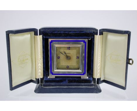 A silver and enamel desk clock, London 1984,square dial applied with arabic numerals, the case decorated with  blue enamel , 