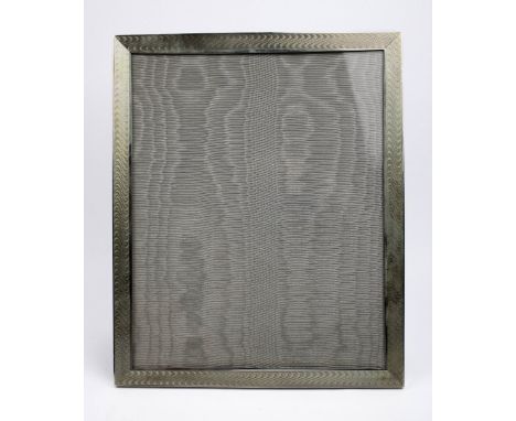 A large silver photograph frame with engine turned decorated borders and strut back support, London 2007, 23.2cm X 28.3cm. Ma