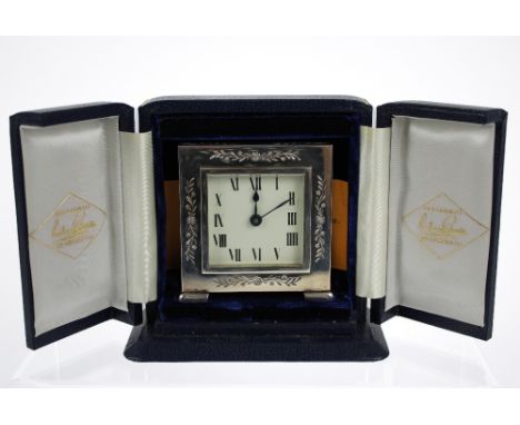 A silver desk clock, London 1983, square dial applied with roman numerals, the case with folate decoration, 7cm x 7cm , in a 