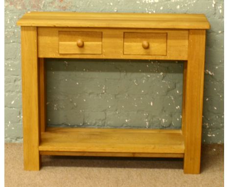 A light oak two drawer hall table with undertier.