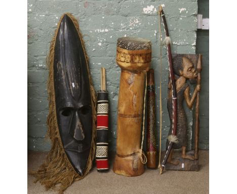 A quantity of tribal items including a drum, large decorative mask, bow and arrow, didjeridoo and an African carving.