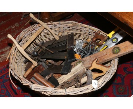 A wicker basket and contents of hand tools to include saws, chisels, planes etc.