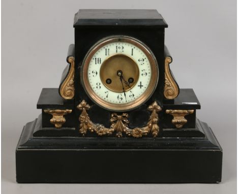 A Victorian slate mantel clock with white enamel dial.