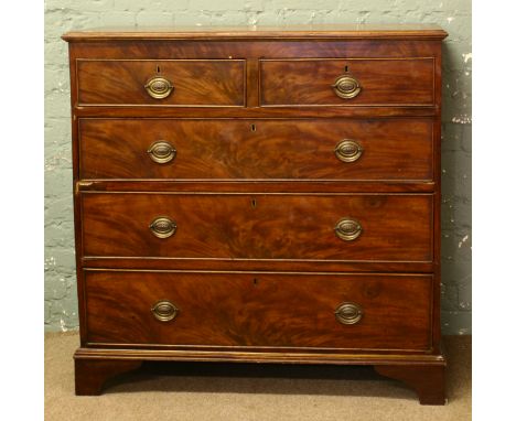 A Georgian mahogany two over three chest of drawers crossbanded and raised on bracket feet.