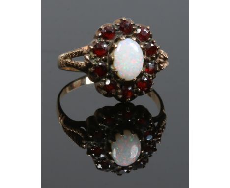 A 9ct gold opal and garnet coronet cluster ring set on openwork shoulders, size O.