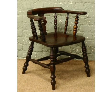 A stained oak smokers bow arm chair with bobbin turned supports.