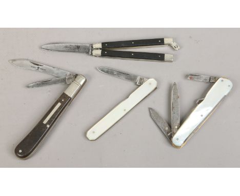 Two multi tool folding pocket knives with mother of pearl scales along with two other folding pocket knives.