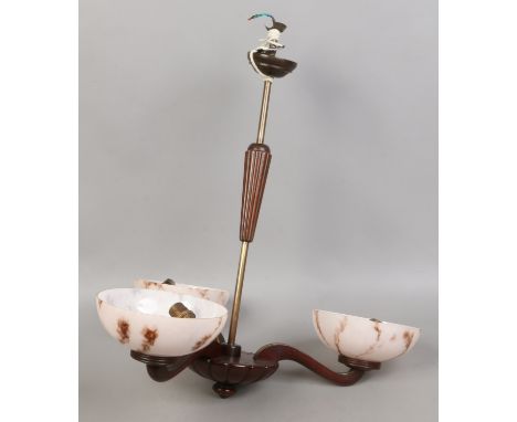 A 1970s three branch mahogany and brass ceiling light fitting with pink marbelized glass shades.