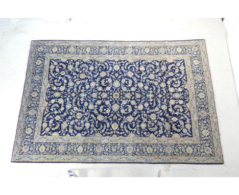Kashan woollen carpet, deep blue field dispersed with sky blue and ochre palmettes within a deep blue palmette border,  361cm