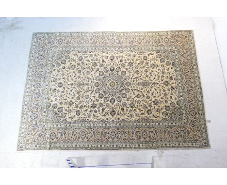Kashan woollen carpet, fawn field dispersed with midnight blue palmettes within a sage green palmette border, 348cm x 248cm 