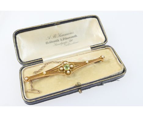 Edwardian peridot and pearl bar brooch, circa 1910, the central round peridot approx. 5mm diameter, in a beaded collet mount 