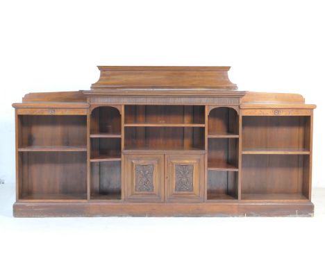 Late Victorian walnut open bookcase, by Rumney &amp; Co., Liverpool, circa 1900, having a central section with two lower carv