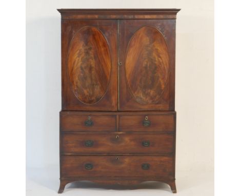 Regency mahogany linen press, circa 1810-20, moulded cornice over two recessed oval panel flame mahogany doors, opening to ha
