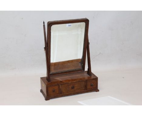 18th century-style walnut toilet mirror, the rectangular bevelled mirror plate with re-entrant angles raised on three drawer 