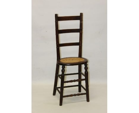 19th century beech child's correctional chair, having high ladder back and rush seat on splayed turned understructure