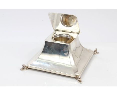 1920s silver Egyptian revival-style inkwell of tapering square form, with canted corners and flat hinged cover, on four sphin