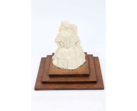 Early Victorian Parian ware figure of HM Queen Victoria seated in an armchair with moulded Royal coat of arms on reverse and 