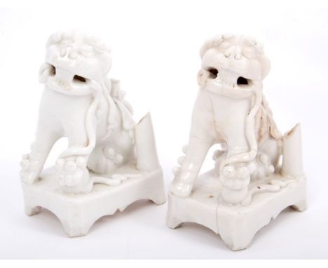 Pair of late 17th / early 18th century Chinese blanc-de-chine porcelain figures of dogs of foo with incense stick holders, on