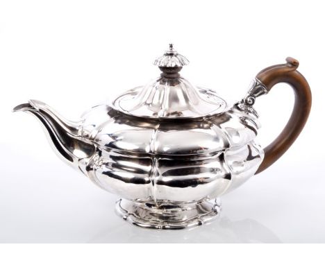 George IV silver teapot of compressed melon form, with flared rim, fruitwood scroll handle and hinged domed cover with silver