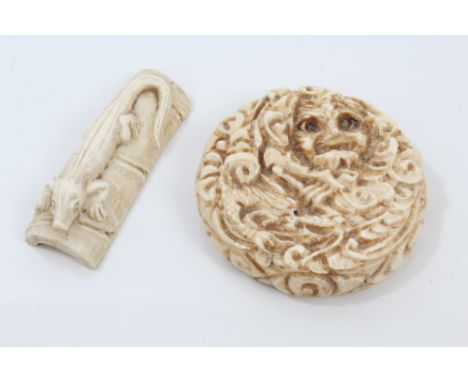 Late 19th century Japanese carved ivory netsuke in the form of a disc, with human mask and dragon decoration and another of a