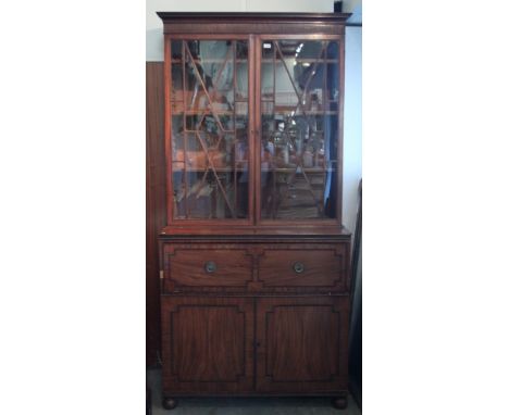 Regency mahogany secretaire bookcase with reeded cornice and adjustable shelves enclosed by pair of astragal glazed doors, th