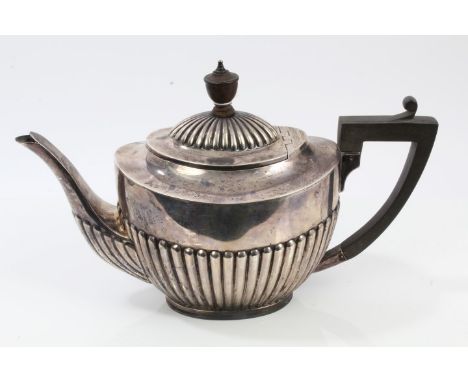 Late Victorian silver teapot of half fluted form, engraved armorial crest, with angular ebony handle, hinged domed and fluted