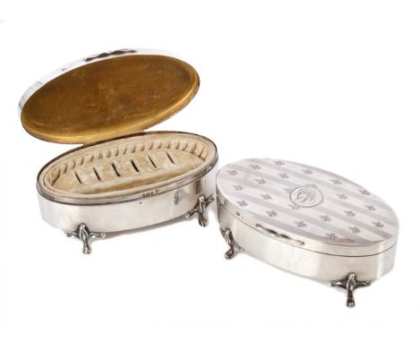 Pair of late Edwardian silver dressing table jewellery boxes of oval form, with velvet interiors, hinged domed covers with en