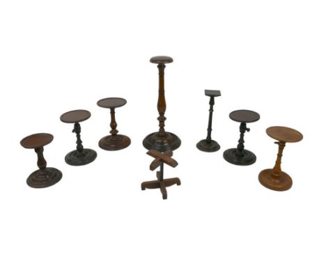 A collection of wooden wig stands and candlestick holders, including a 19th century mahogany wig stand with turned column and