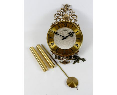 A modern Schmeckenbecher wall clock, brass chapter ring with black Roman numerals, 23cm, black hands, silvered foliate engrav
