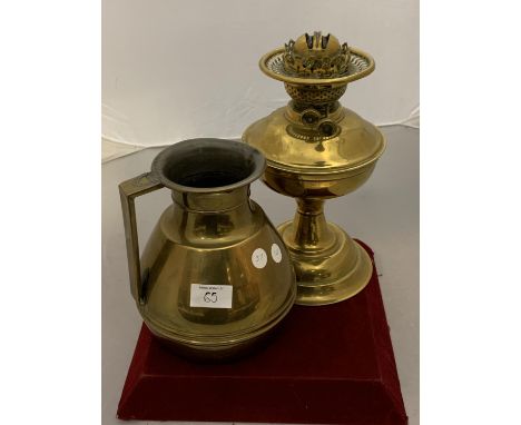 A LARGE BRASS JUG AND A BRASS OIL LAMP BASE 