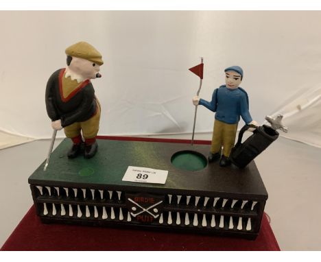 A CAST IRON MONEY BOX WITH A MOVABLE GOLFER AND CADDY 